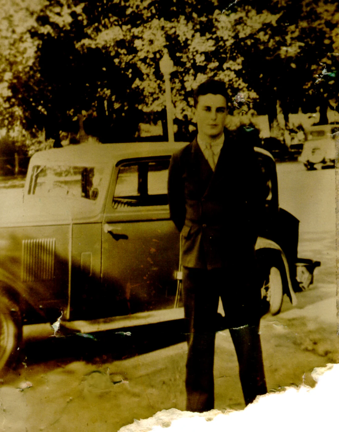 Original photograph of a man by a car, heavily damaged
